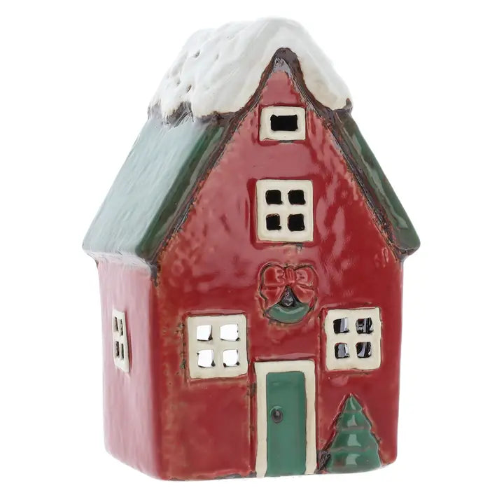 Small ceramic tealight house with a red roof and green door on a white background
