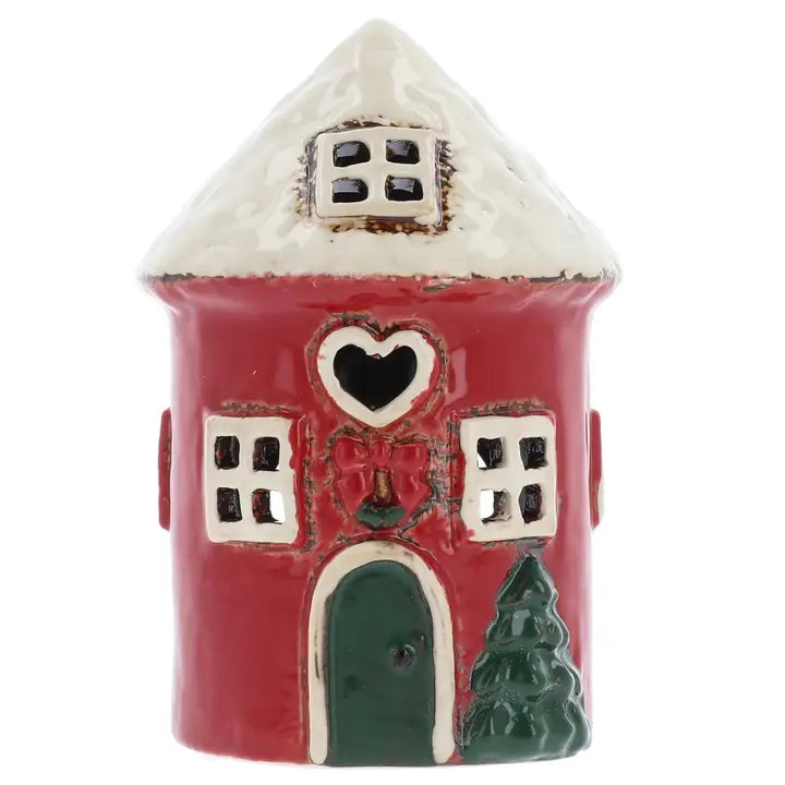 Ceramic house-shaped tealight holder with a red body, white roof, and green door on a white background.