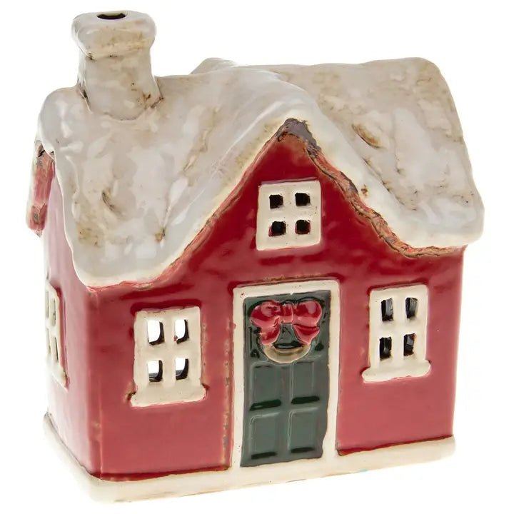 Small ceramic tealight house with a red door and white roof on a white background