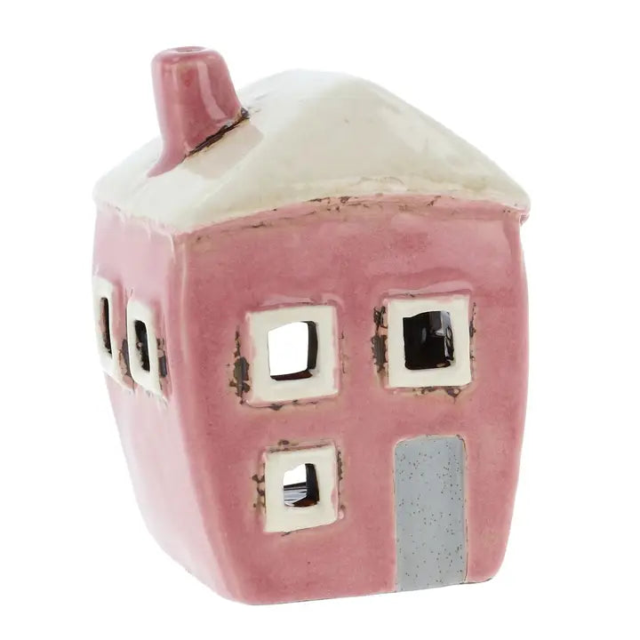 Pink ceramic house-shaped tealight holder with white roof on a white background