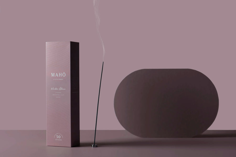 Incense stick with packaging and a diffuser on a pink background