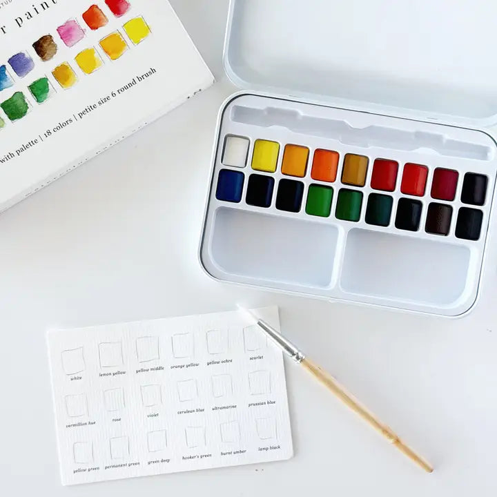 Watercolor paint set with color swatches on a white surface