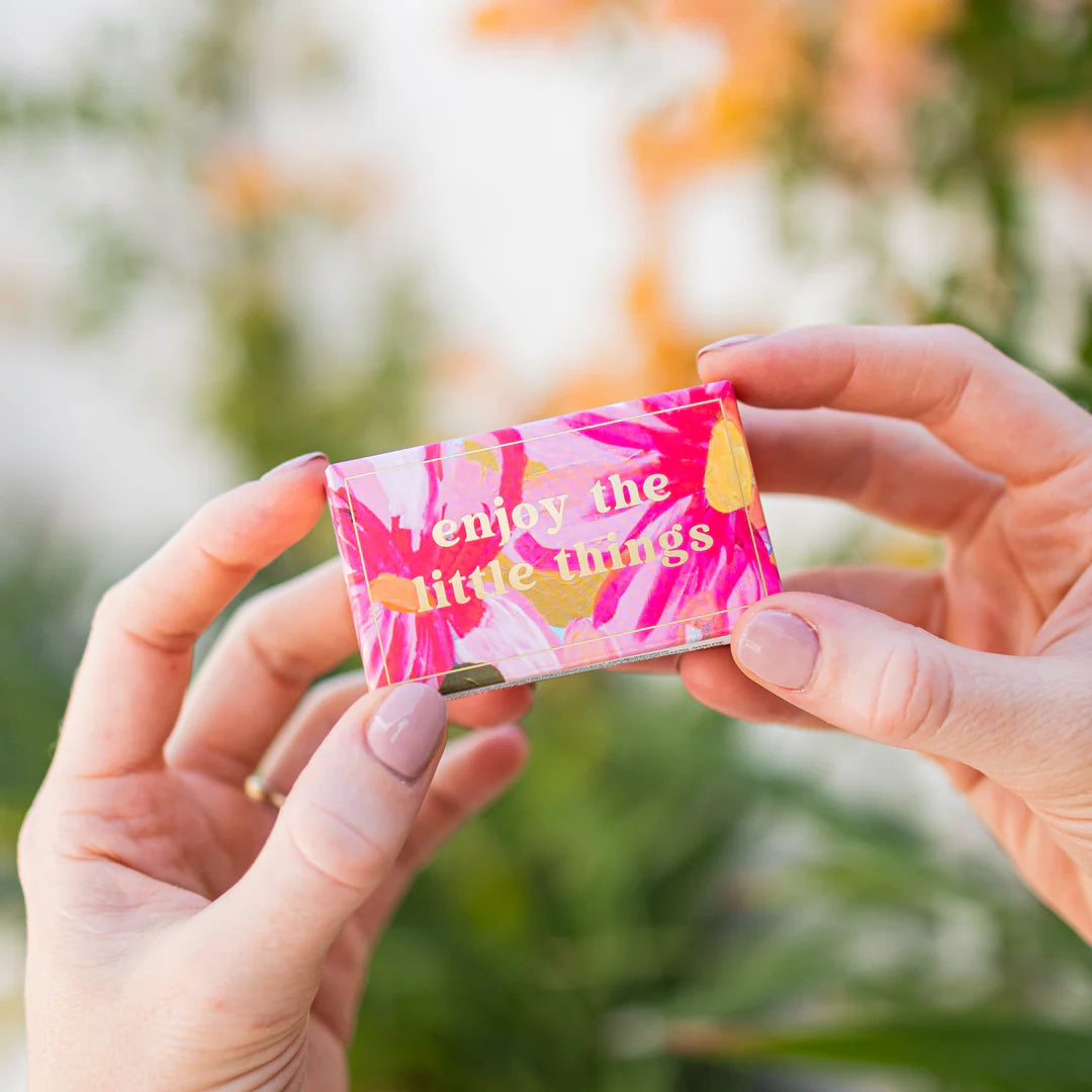 Person holding a pink and yellow box with &