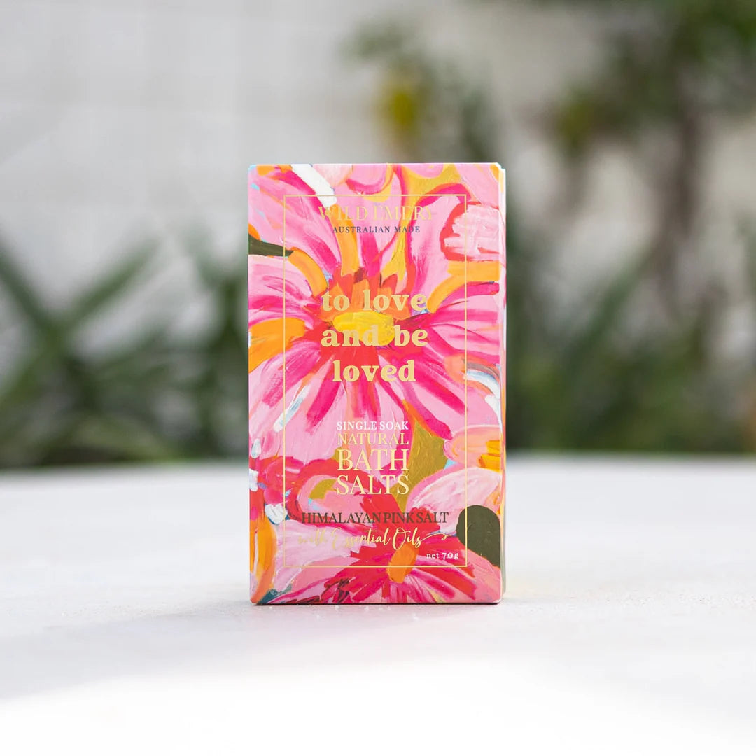 Bath salts packaging with floral design on a white surface