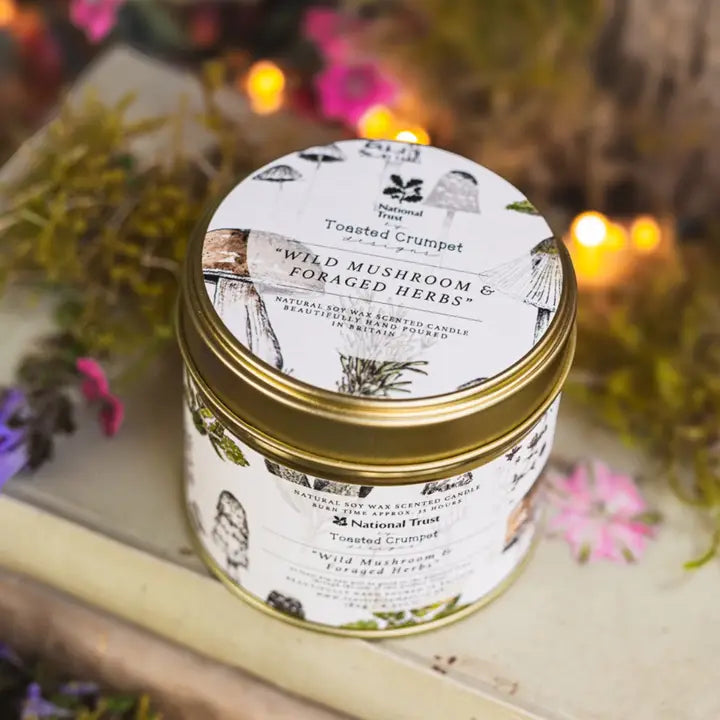 Candle jar with decorative label on a wooden surface with blurred natural background