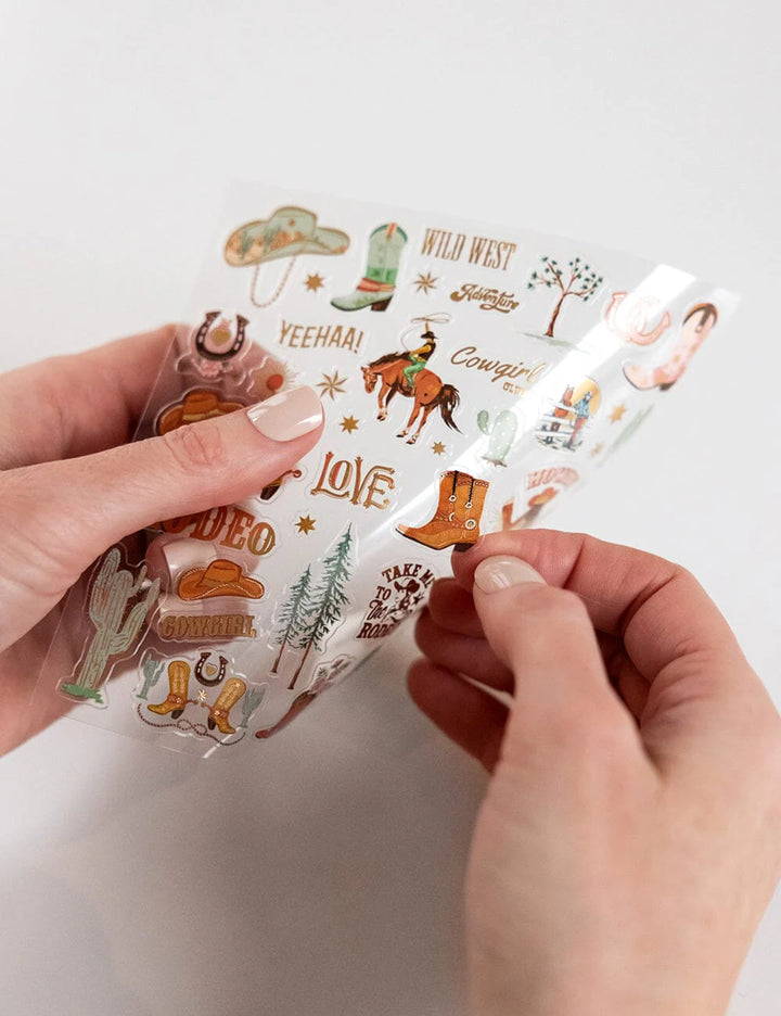 Hand holding a clear package with cowboy-themed illustrations on a white background