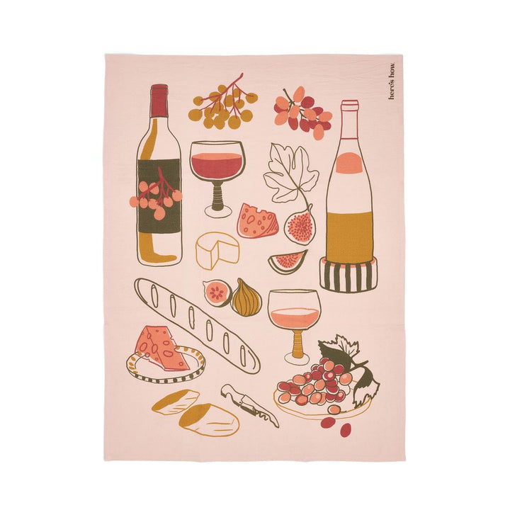 Tea towel with wine-themed illustrations on a pink background