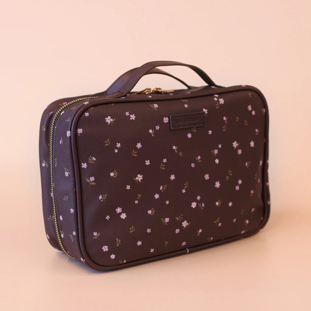 Floral-patterned cosmetic case on a beige background