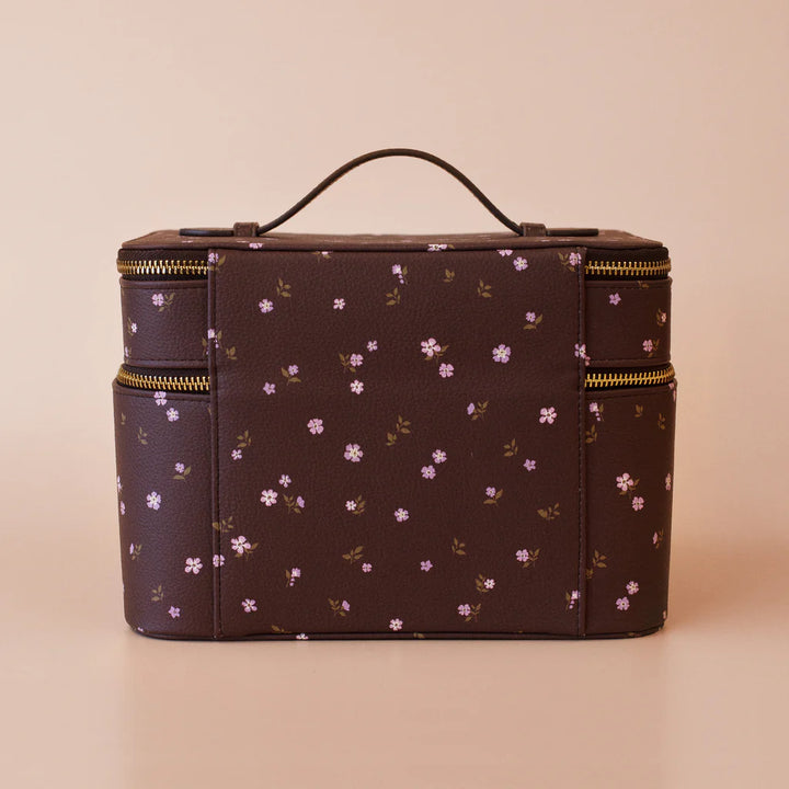 Floral-patterned makeup bag with gold zippers on a beige background