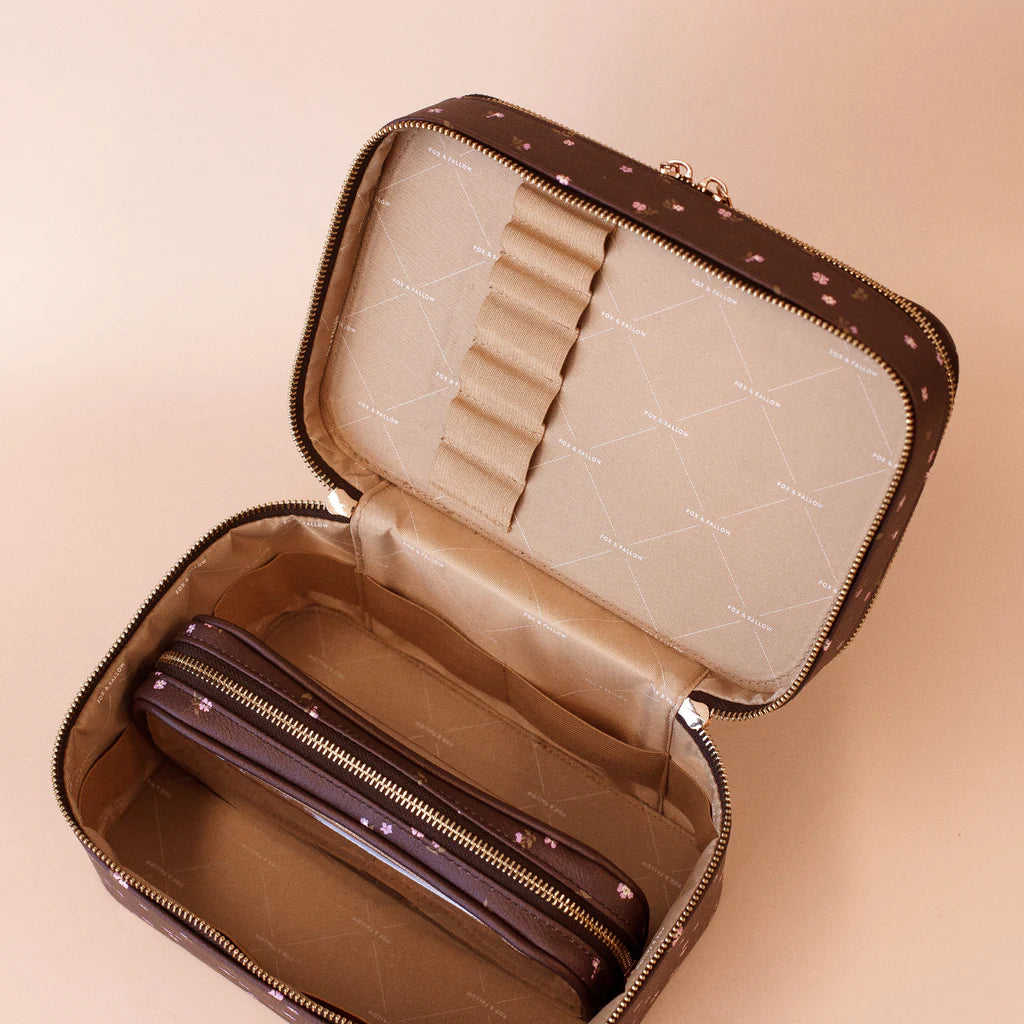 Open vanity case items on a beige background