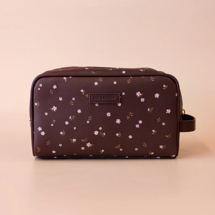 Floral-patterned toiletry bag on a beige background
