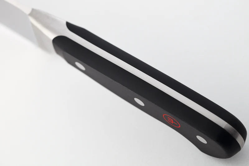 Black metal tool with a red label on a light gray background
