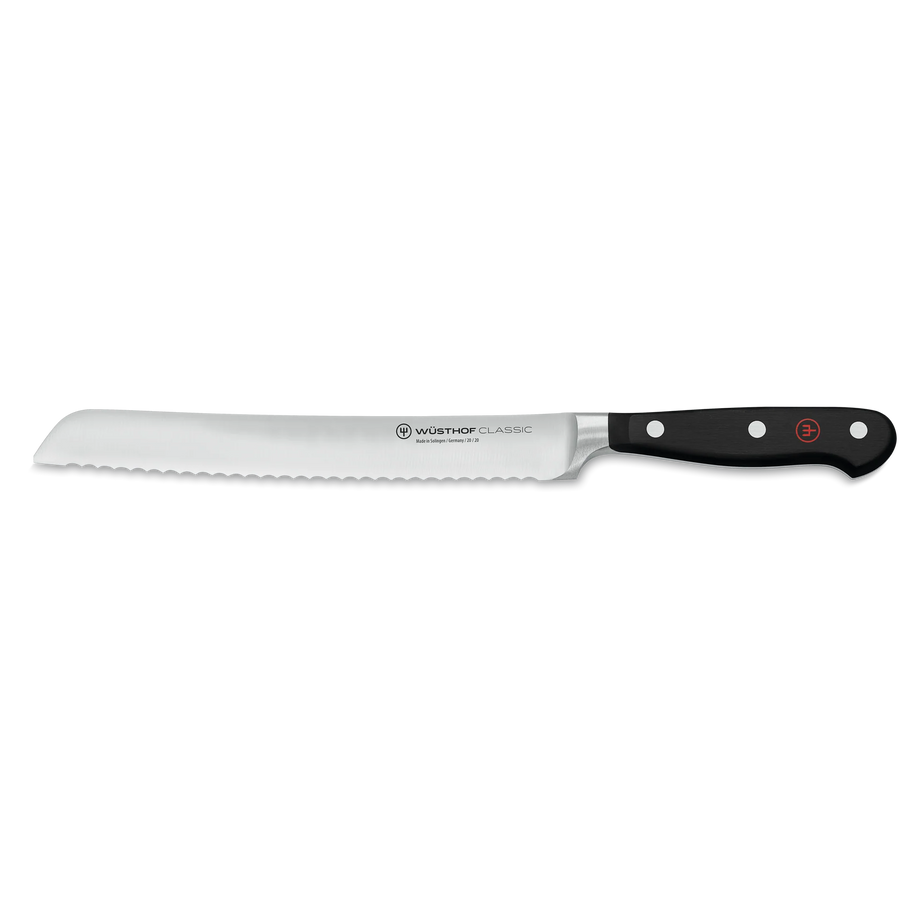 Serrated bread knife with black handle on a white background