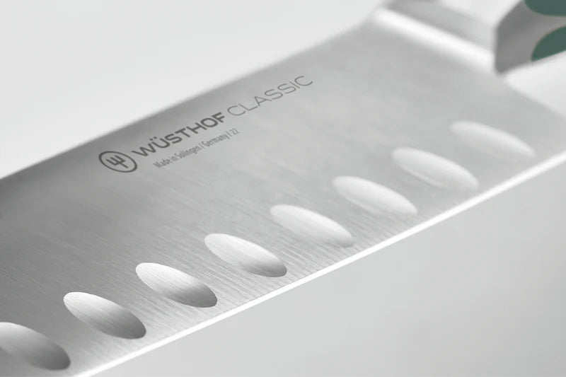 Close-up of a Wüsthof Classic Santoku knife blade on a white background