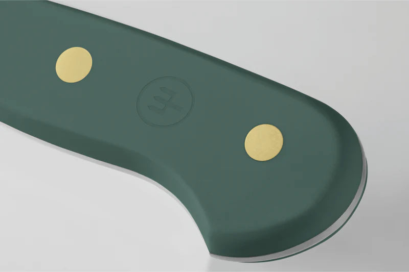 Green handle knife with gold circular accents on a light gray background