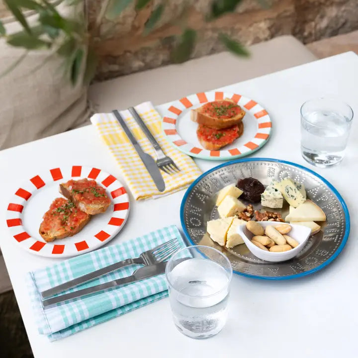 Table setting with plates of food, glasses of water, and cutlery on a white table.