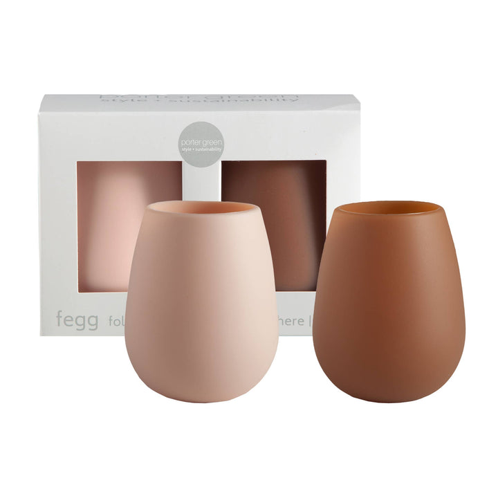 Two matte silicone unbreakable drinkware pieces, one in dusty pink and one in terracotta brown, displayed in front of their white packaging box on a white background.