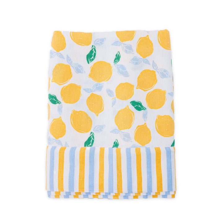 White linen tablecloth with lemon and blue pattern, folded and laid flat on a white background