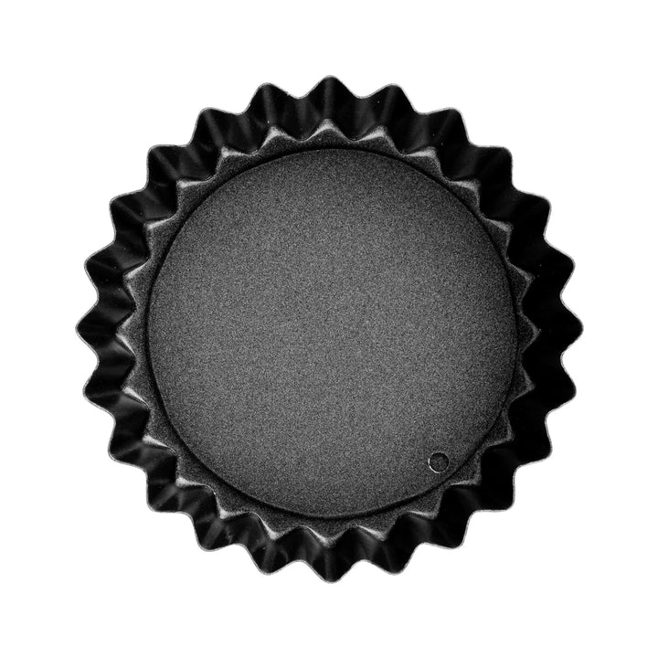 Black fluted quiche pan on a white background
