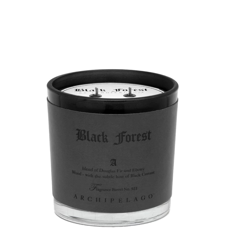 Candle in a black container labeled 'Black Forest' by Archipelago on a white background