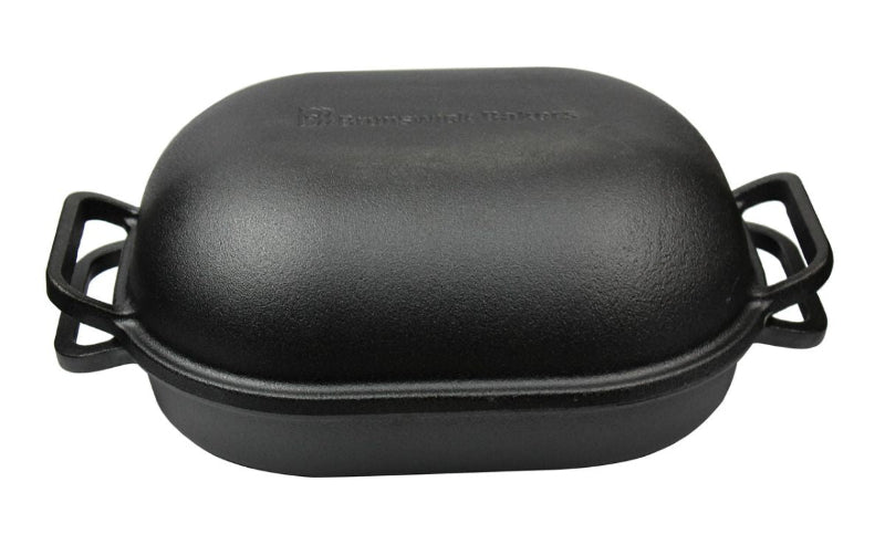 Black cast iron roaster with handles on a white background