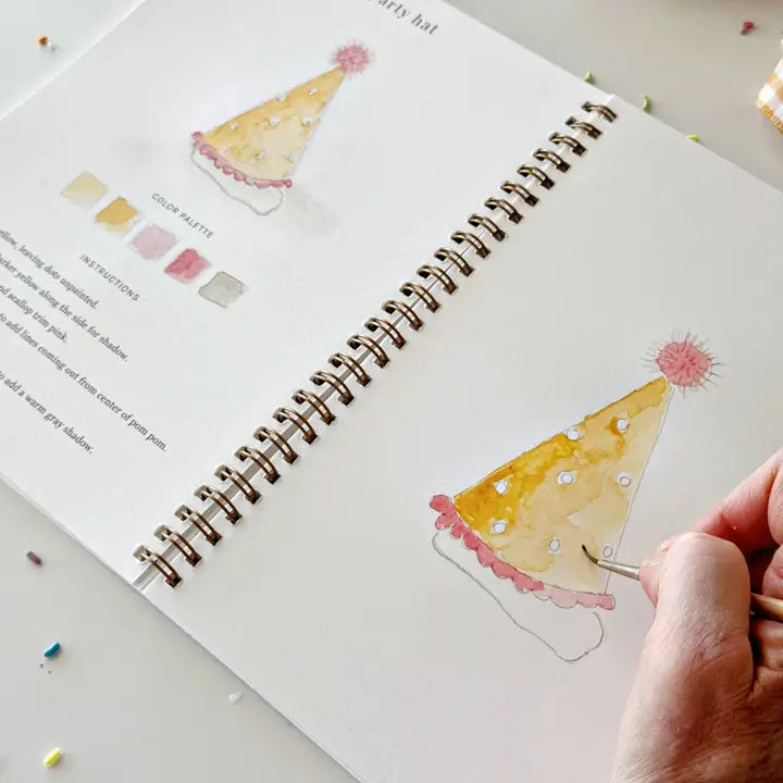 A hand painting a birthday hat