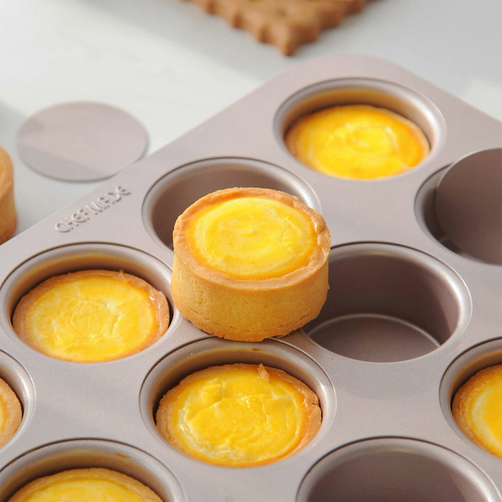 Egg tarts in a muffin tin on a white surface