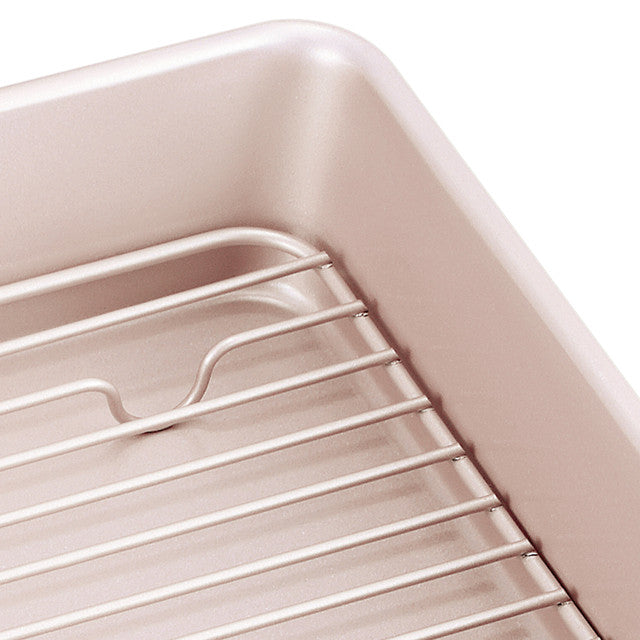 Close-up of a baking dish with a wire rack inside on a white background