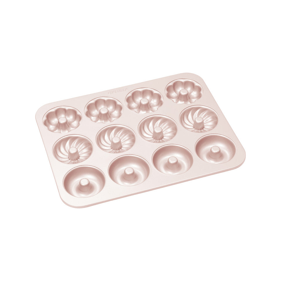 Rose gold donut-shaped baking mold on a white background