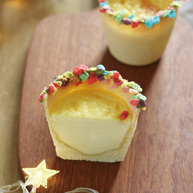 Half-eaten dessert with colorful sprinkles on a wooden surface