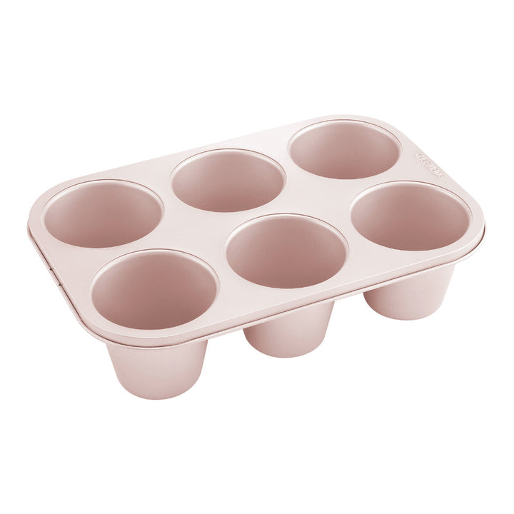 Pink muffin tin with six compartments on a white background