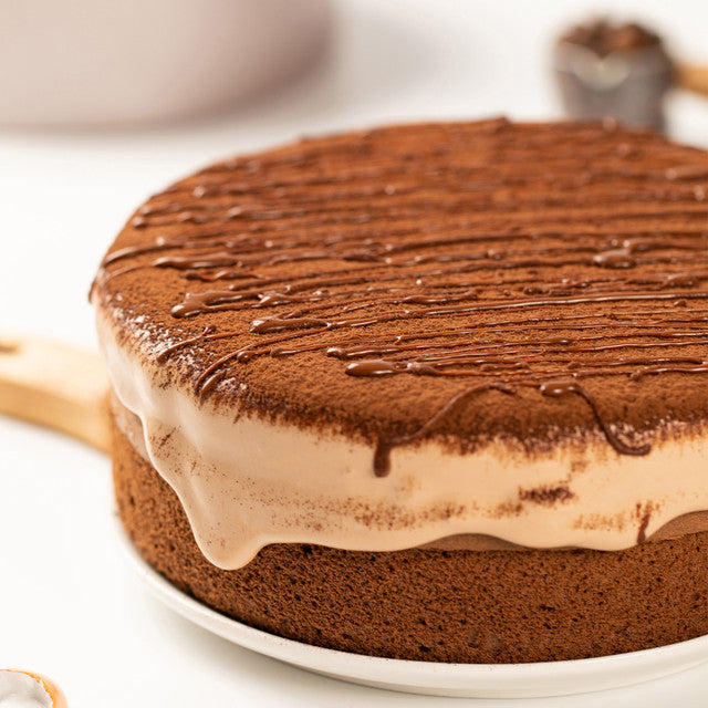 Chocolate cake with a layer of cream on a white plate