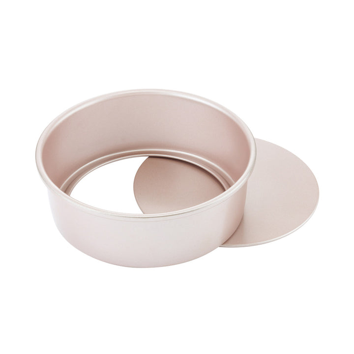 Pink cake pan with a loose base on a white background