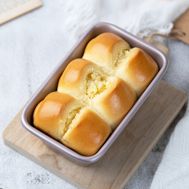 A small loaf tin with bread in it