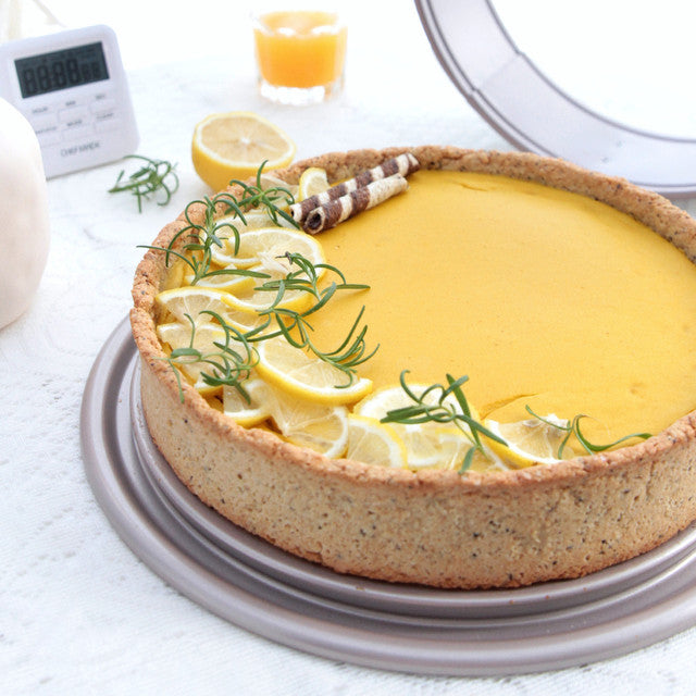Lemon tart with a graham cracker crust on a white surface