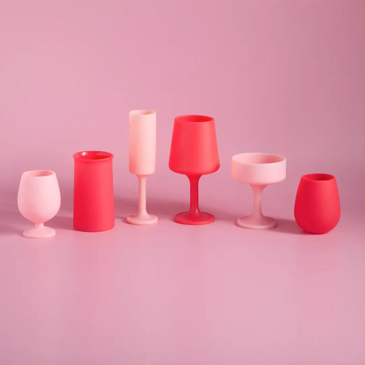 Set of pink and red silicone glassware on a pink background