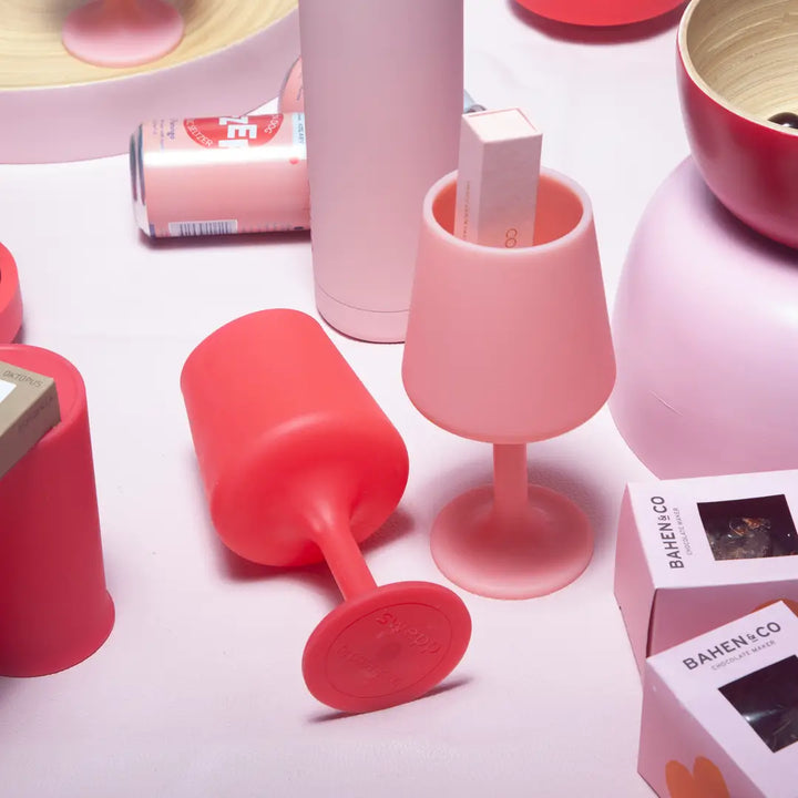 Pink and red silicone cups on a white surface with &