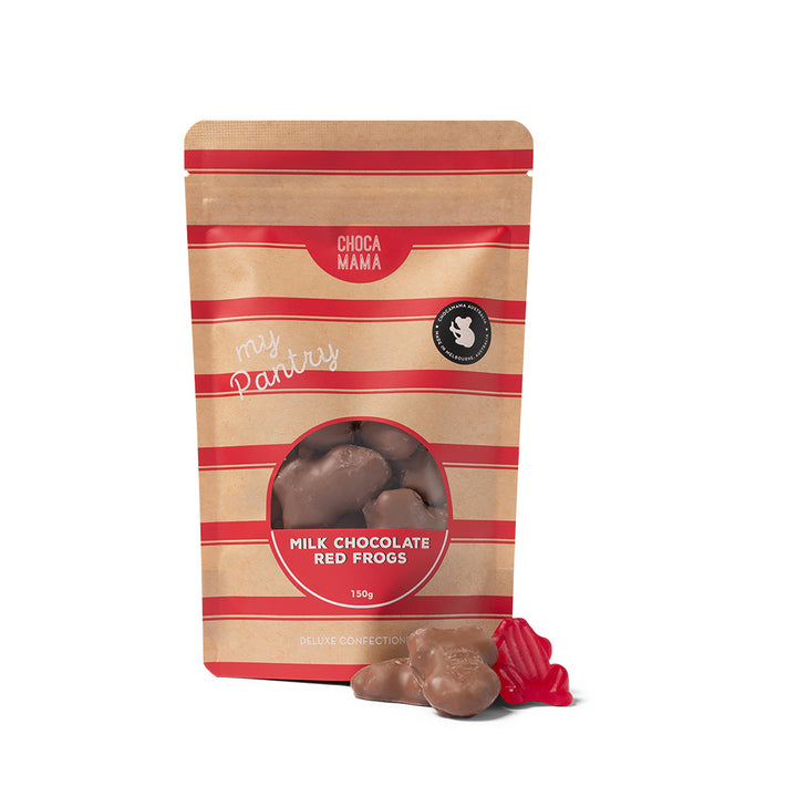 A kraft bag of Chocamama milk chocolate covered red frogs with red stripes on the packet a clear section to see the frogs inside. Plus some frogs in front of the packet, on a white background.
