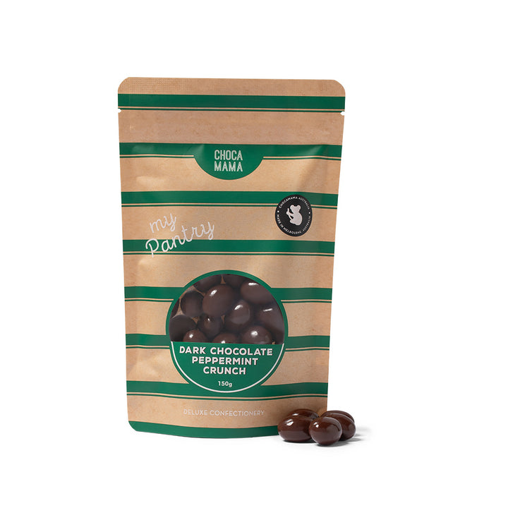 A stand-up pouch of Choca Mama Dark Chocolate Peppermint Crunch candies on a white background, with three chocolate pieces placed in front of the package.