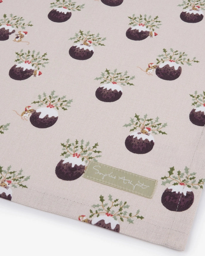 A fabric tea towel featuring a repeating pattern of Christmas puddings on a white background