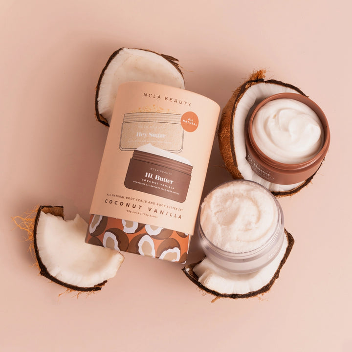 NCLA Beauty coconut vanilla body butter with coconut halves on a beige background