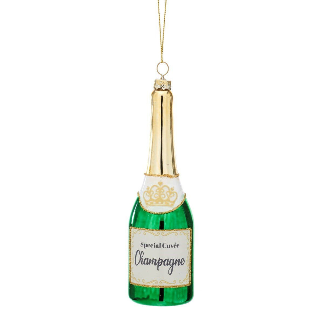 A champagne bottle-shaped Christmas ornament with a green glass body, gold foil neck, white label, and hanging loop, shown on a plain white background.