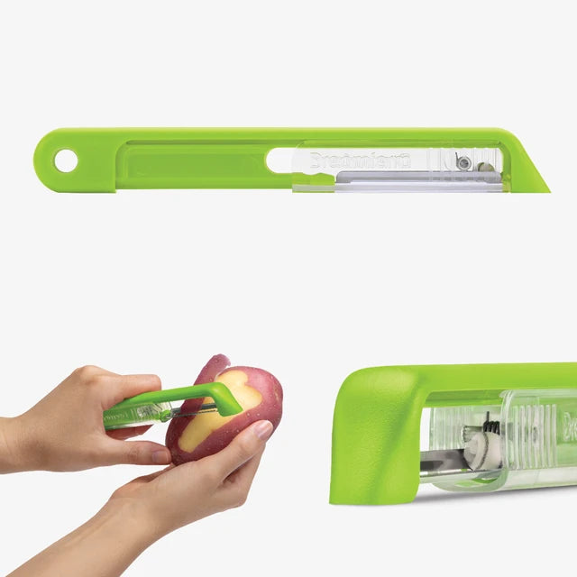Green apple peeler being used to peel a potato on a white background
