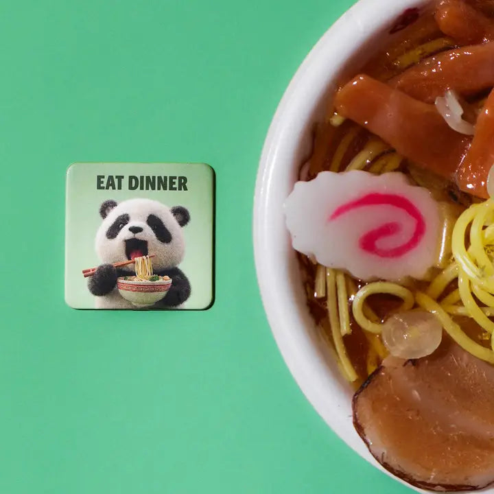 A square coaster featuring a cute cartoon panda eating ramen with the text &