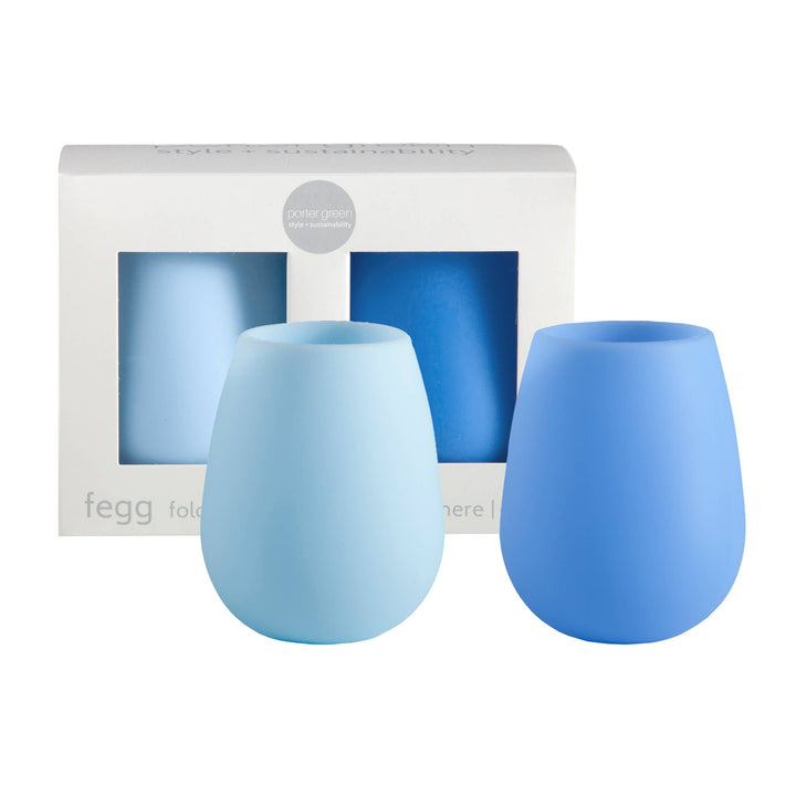 Two blue silicone tumblers in front of their packaging on a white background