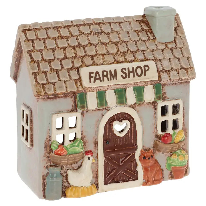 A ceramic farm shop tealight holder with vegetables, chicken and a cat on a white background