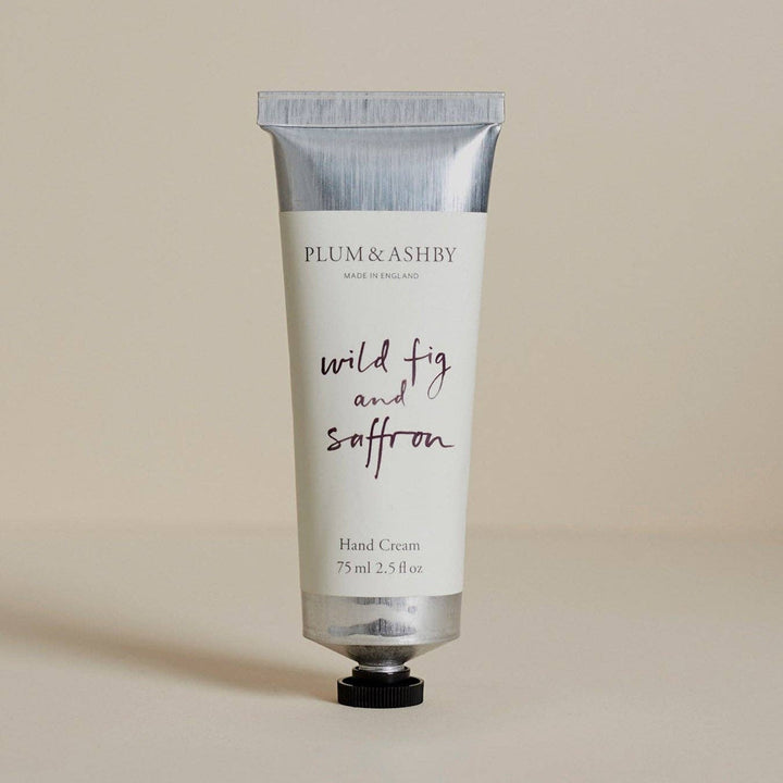 A squeeze tube of Plum &amp; Ashby hand cream with a white label and silver cap, standing upright on a neutral beige background.