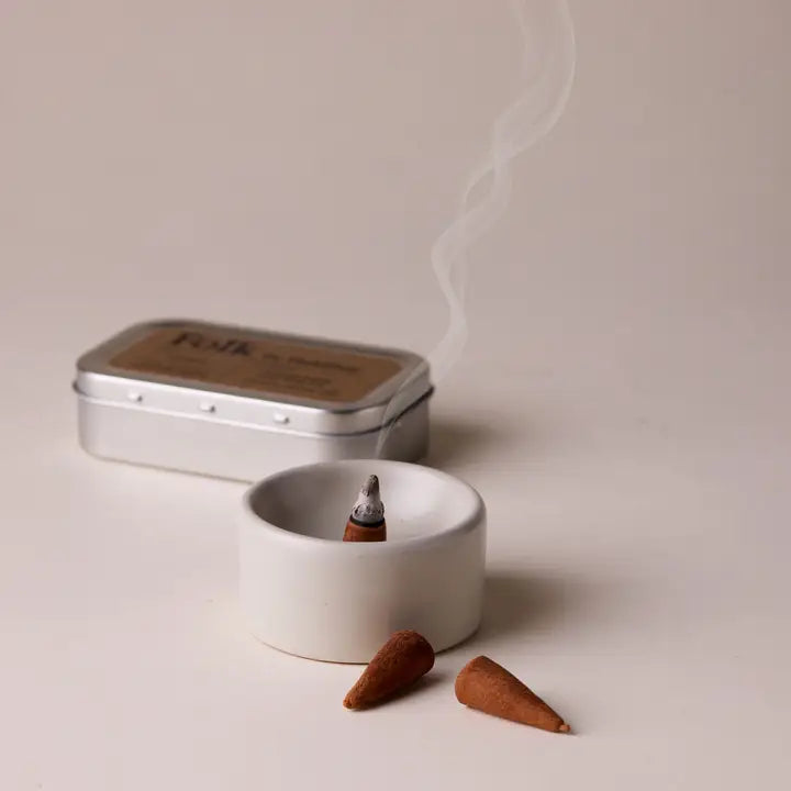 Incense cones and a tin on a light background