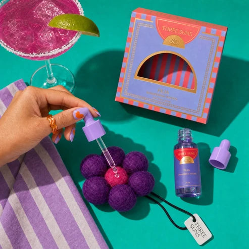 Three Suns product with purple and pink elements on a green background