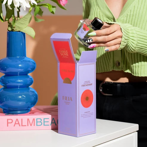 Person holding a reed diffuser bottle with a &
